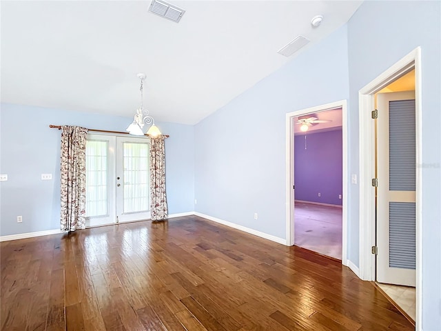 unfurnished room featuring hardwood / wood-style flooring, ceiling fan with notable chandelier, vaulted ceiling, and french doors