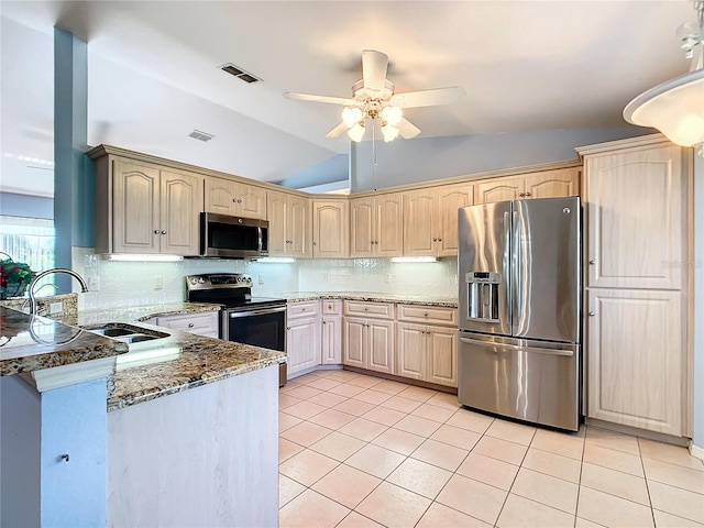 kitchen featuring kitchen peninsula, appliances with stainless steel finishes, decorative backsplash, ceiling fan, and lofted ceiling