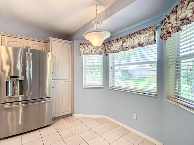 kitchen with stainless steel refrigerator with ice dispenser, light tile patterned floors, and hanging light fixtures