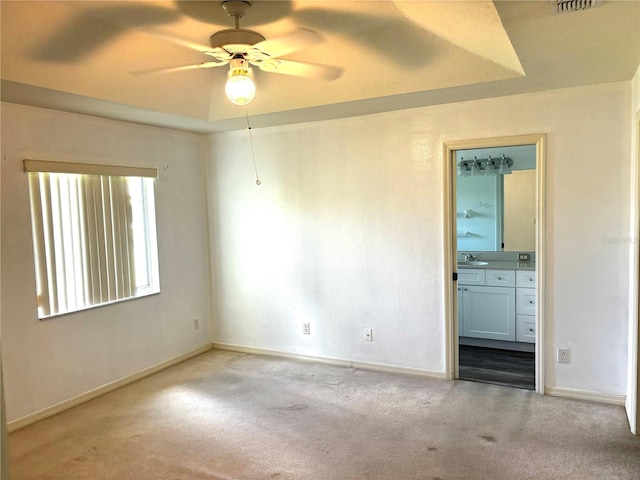 spare room featuring ceiling fan, sink, and light colored carpet