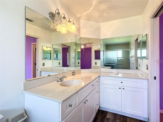 bathroom featuring vanity, wood-type flooring, and a shower with shower door