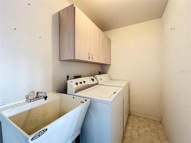 washroom featuring sink, cabinets, a textured ceiling, and independent washer and dryer