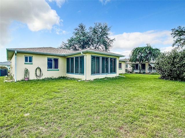 back of house featuring a sunroom and a yard