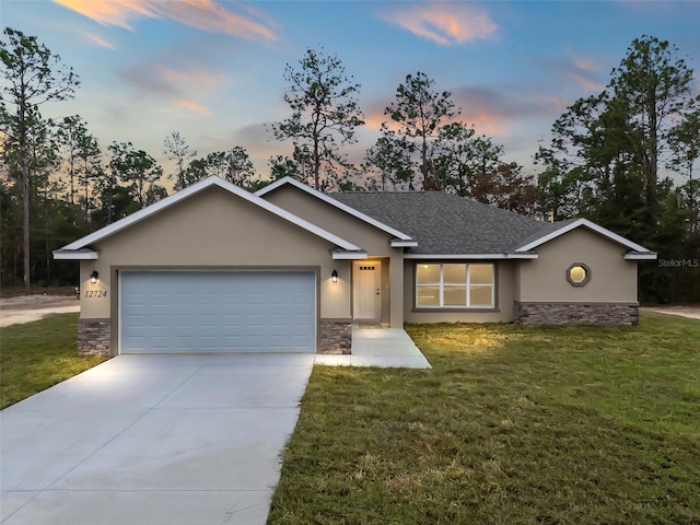 view of front facade with a yard and a garage