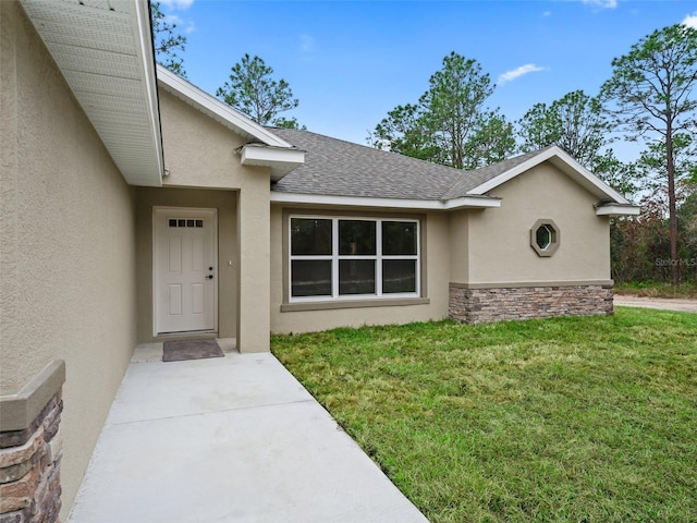 property entrance with a lawn