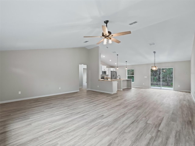 unfurnished living room featuring ceiling fan, light hardwood / wood-style floors, sink, and vaulted ceiling