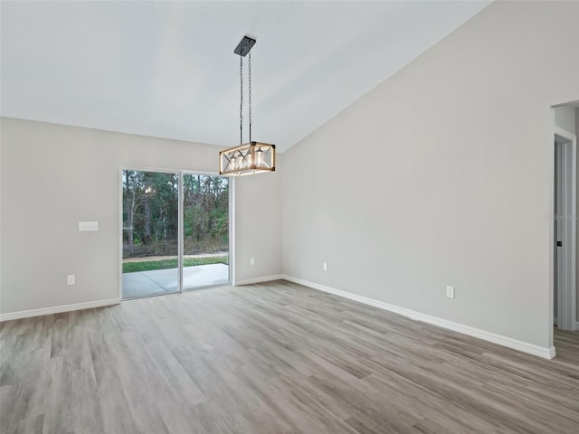 empty room with light hardwood / wood-style flooring and lofted ceiling