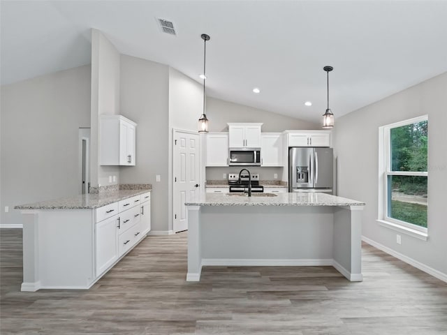 kitchen with pendant lighting, white cabinets, stainless steel appliances, and light wood-type flooring