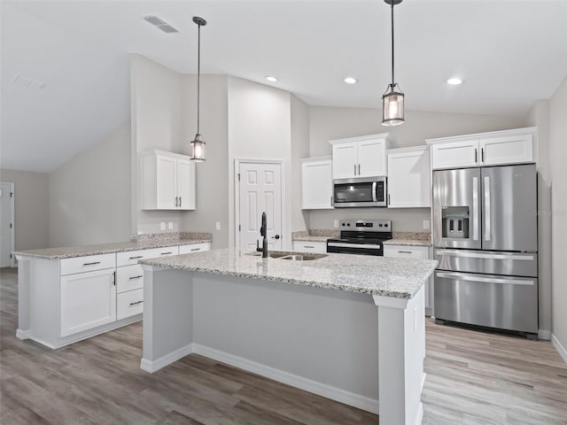 kitchen with white cabinets, sink, light hardwood / wood-style flooring, decorative light fixtures, and stainless steel appliances