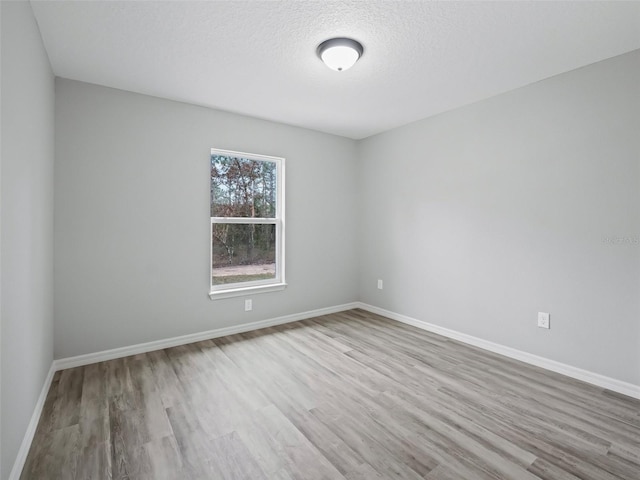 empty room featuring light hardwood / wood-style floors and a textured ceiling