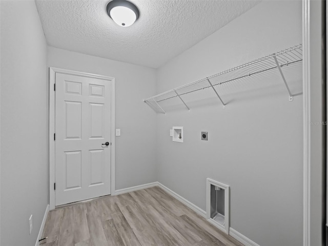 washroom featuring light hardwood / wood-style flooring, washer hookup, a textured ceiling, and hookup for an electric dryer