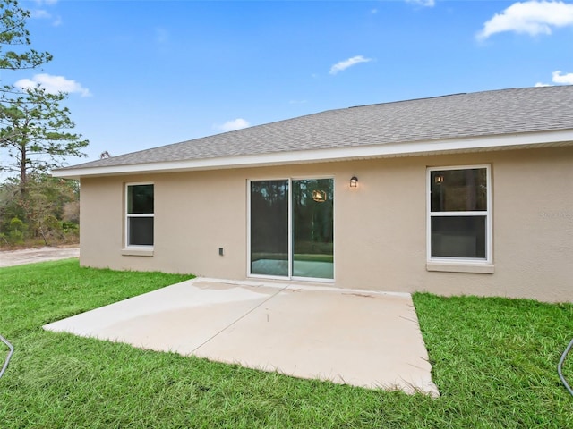 back of property featuring a lawn and a patio