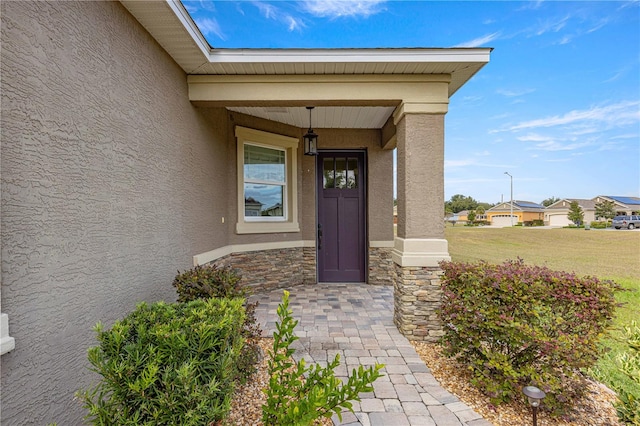 property entrance featuring a yard and covered porch