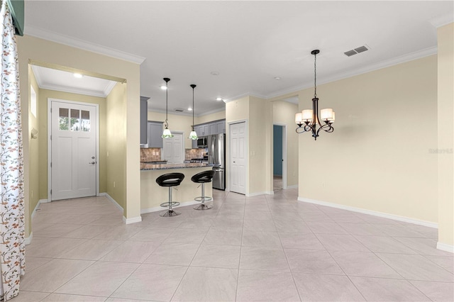 kitchen with a kitchen breakfast bar, hanging light fixtures, light tile patterned flooring, stainless steel appliances, and a chandelier