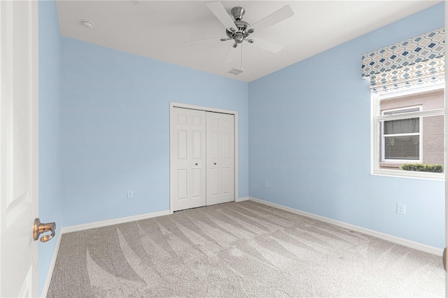 unfurnished bedroom featuring ceiling fan, a closet, and carpet