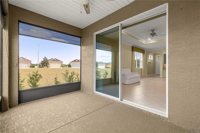 unfurnished sunroom featuring ceiling fan and a tray ceiling