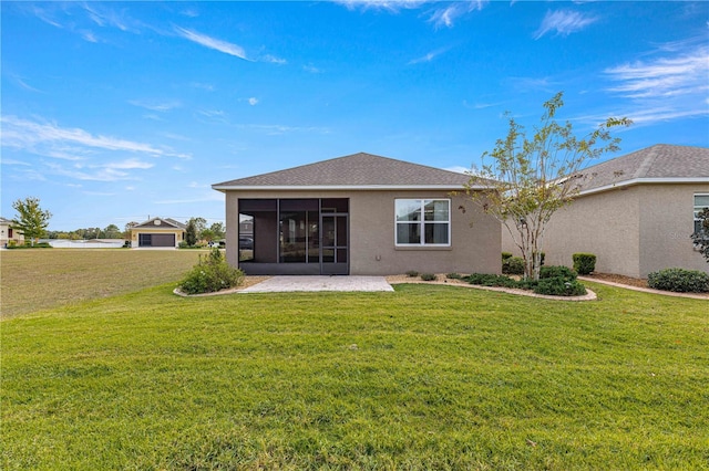 rear view of property with a lawn, a sunroom, and a patio area