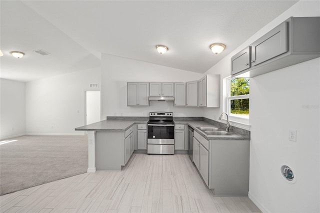 kitchen featuring gray cabinetry, sink, kitchen peninsula, vaulted ceiling, and appliances with stainless steel finishes