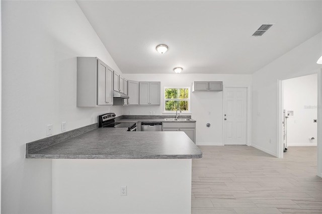 kitchen with kitchen peninsula, appliances with stainless steel finishes, sink, gray cabinets, and lofted ceiling