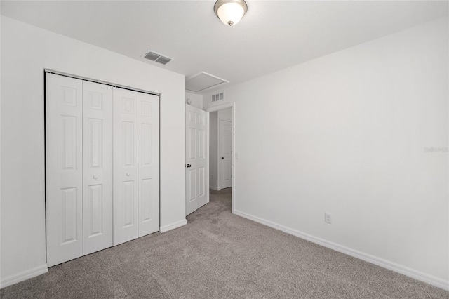 unfurnished bedroom featuring light colored carpet and a closet