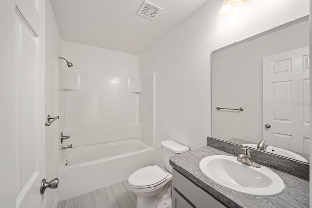 full bathroom featuring wood-type flooring, a textured ceiling,  shower combination, toilet, and vanity