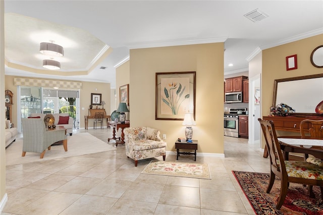 living room with light tile patterned flooring, a raised ceiling, and ornamental molding