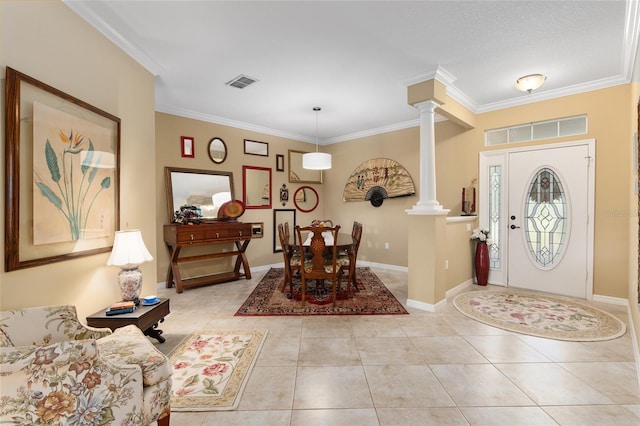 foyer entrance featuring light tile patterned floors, ornate columns, and crown molding