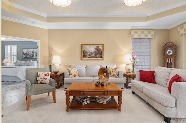 carpeted living room featuring a raised ceiling, ornamental molding, and decorative columns