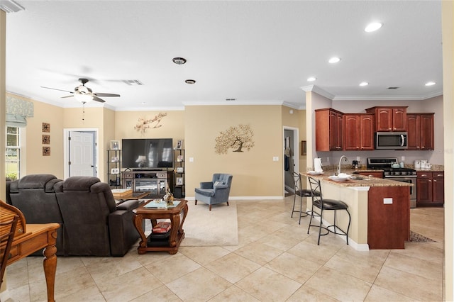 kitchen with ceiling fan, kitchen peninsula, crown molding, a kitchen bar, and appliances with stainless steel finishes