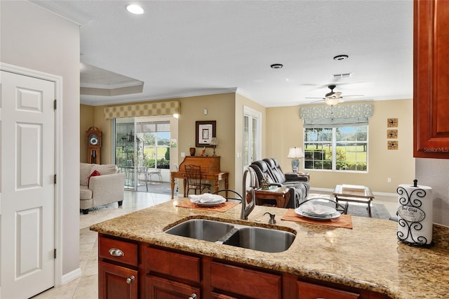 kitchen featuring light stone countertops, a healthy amount of sunlight, and sink