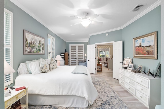 bedroom with light hardwood / wood-style floors, ceiling fan, and ornamental molding