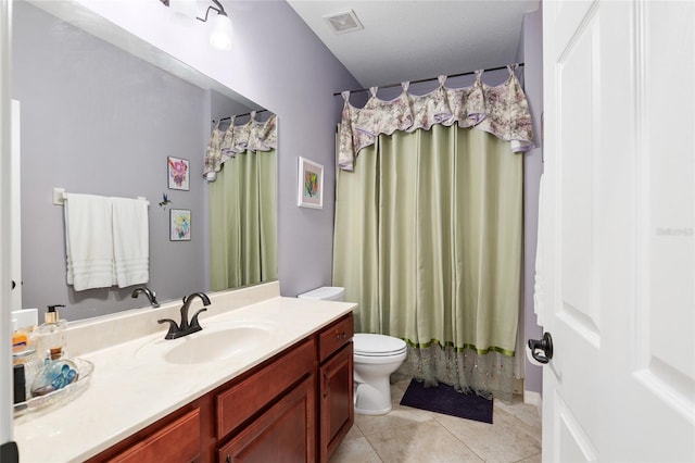 bathroom featuring tile patterned floors, vanity, a textured ceiling, and toilet