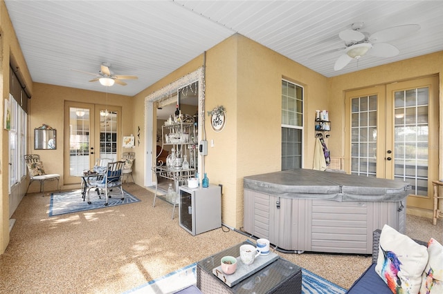 sunroom featuring ceiling fan, french doors, and a hot tub