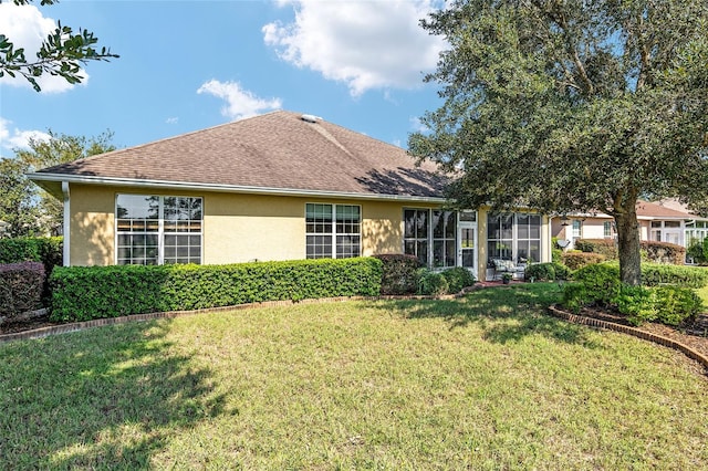 rear view of property featuring a yard