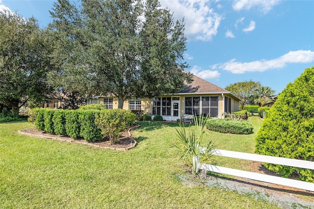 view of front of property featuring a front lawn and a sunroom