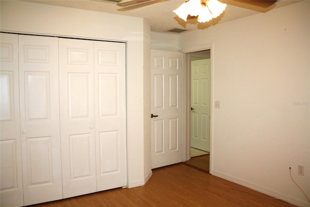 unfurnished bedroom featuring a closet, ceiling fan, and hardwood / wood-style floors