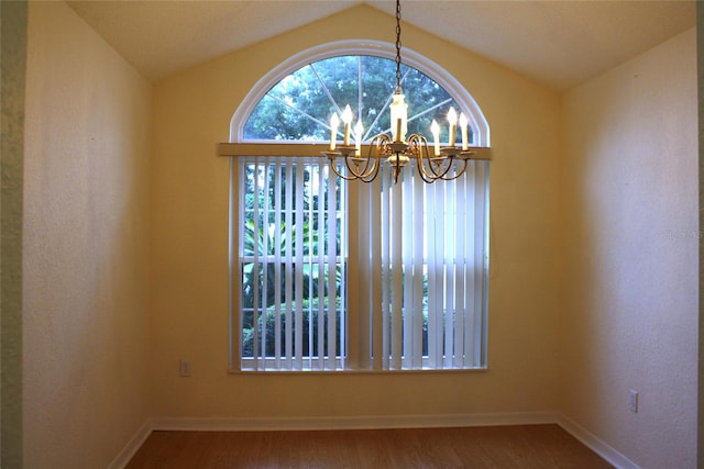 unfurnished dining area with hardwood / wood-style flooring, lofted ceiling, and an inviting chandelier