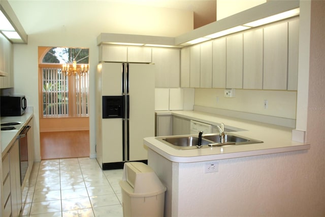 kitchen featuring sink, white refrigerator with ice dispenser, kitchen peninsula, a chandelier, and light tile patterned floors