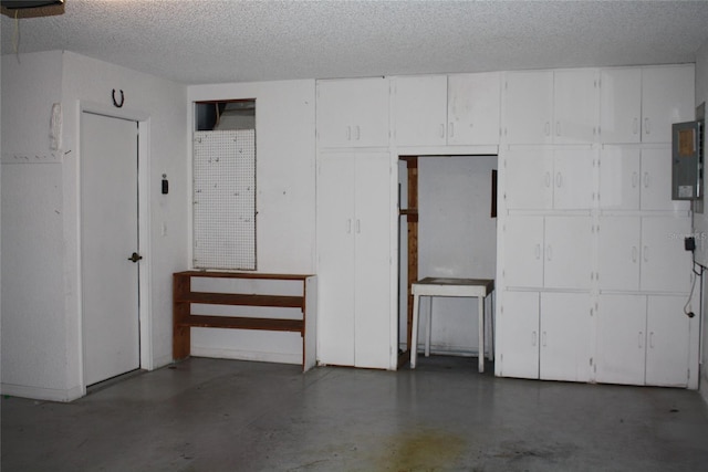 basement featuring a textured ceiling and electric panel