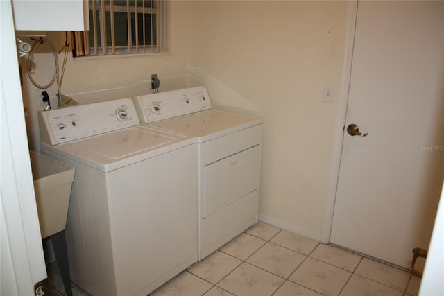 clothes washing area with separate washer and dryer and sink