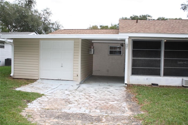 garage with central air condition unit and a yard