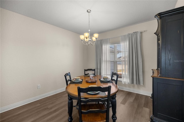 dining area with dark hardwood / wood-style flooring and a chandelier