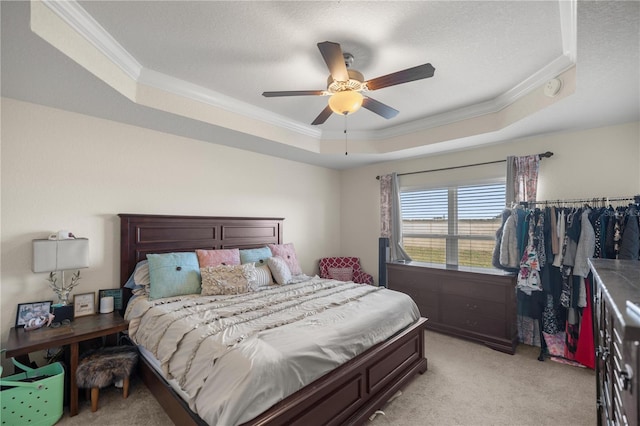 bedroom featuring light colored carpet, a raised ceiling, ceiling fan, and ornamental molding