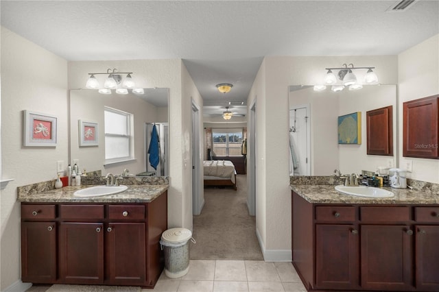 bathroom with tile patterned flooring, vanity, ceiling fan, and a textured ceiling