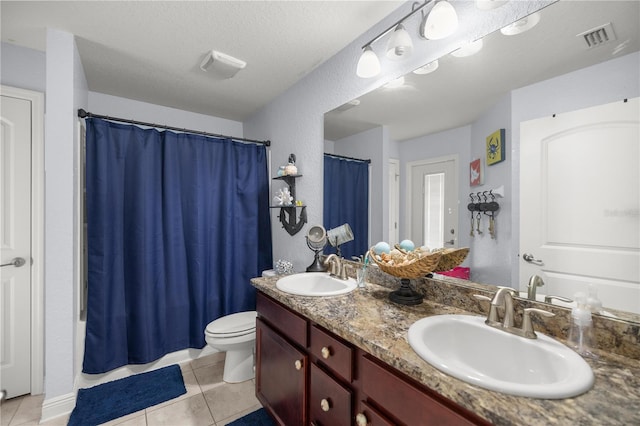 full bathroom with tile patterned flooring, vanity, toilet, and a textured ceiling