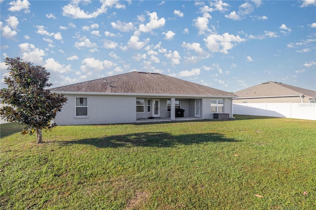 back of house with a lawn and a patio