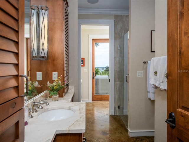 bathroom featuring vanity, a shower with shower door, and crown molding