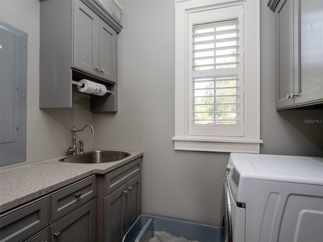 laundry room with cabinets, independent washer and dryer, sink, and electric panel