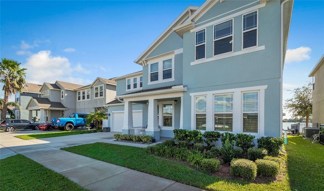 view of front of home featuring central AC, stucco siding, concrete driveway, a garage, and a residential view