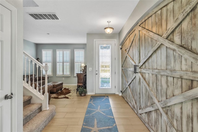 entryway with visible vents, stairs, and baseboards